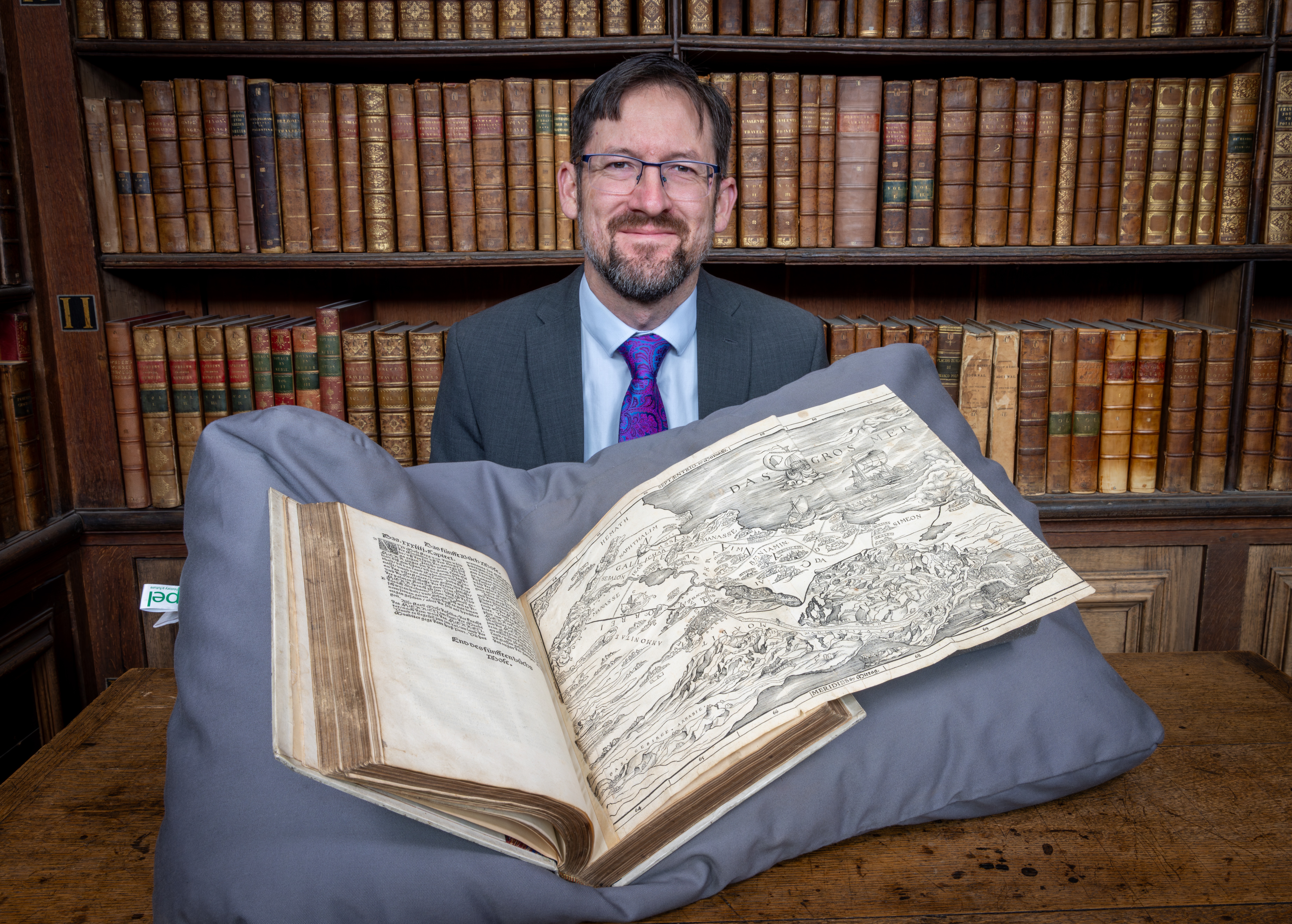 Professor Nathan MacDonald with Christopher Froschauer's 1525 Old Testament open at Lucas Cranach the Elder’s map of the Holy Land, in the Wren Library, Trinity College, Cambridge Professor Nathan MacDonald with Christopher Froschauer's 1525 Old Testament open at Lucas Cranach the Elder’s map of the Holy Land, in the Wren Library, Trinity College, Cambridge